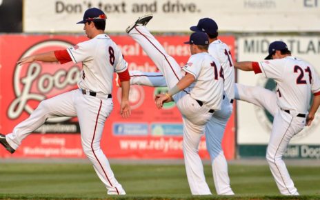 Players stretch before a Minor League Baseball game.
