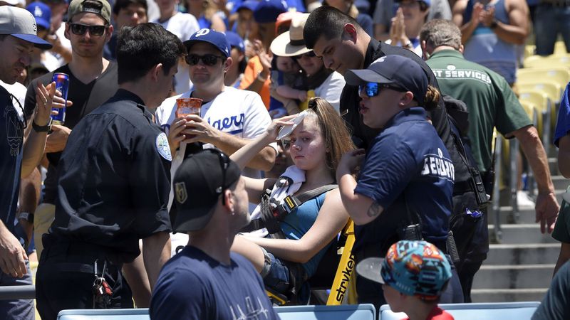 A fan is tended after being hit by a foul ball at Dodgers Stadium.