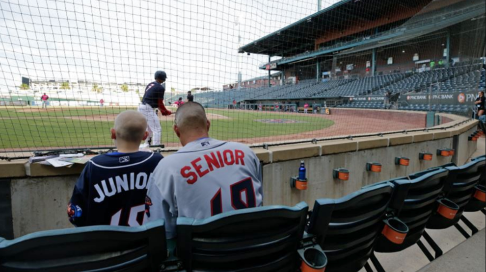 A father and son watch a Jacksonville Jumbo Shrimp game.